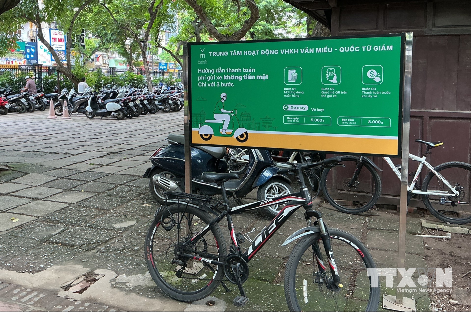 Tại các điểm trông giữ phương tiện trên địa bàn Hà Nội luôn có các biển hướng dẫn trả phí trông giữ phương tiện không dùng tiền mặt. (Ảnh: Nguyễn Thắng/TTXVN)
